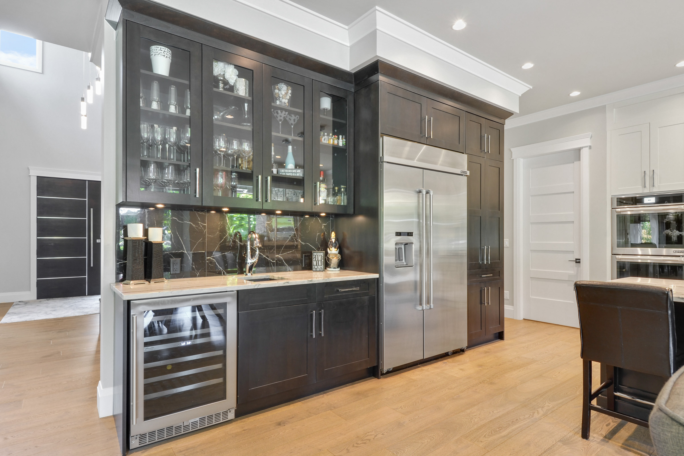 Espresso butler's pantry and bar with glass-front cabinets and wine fridge