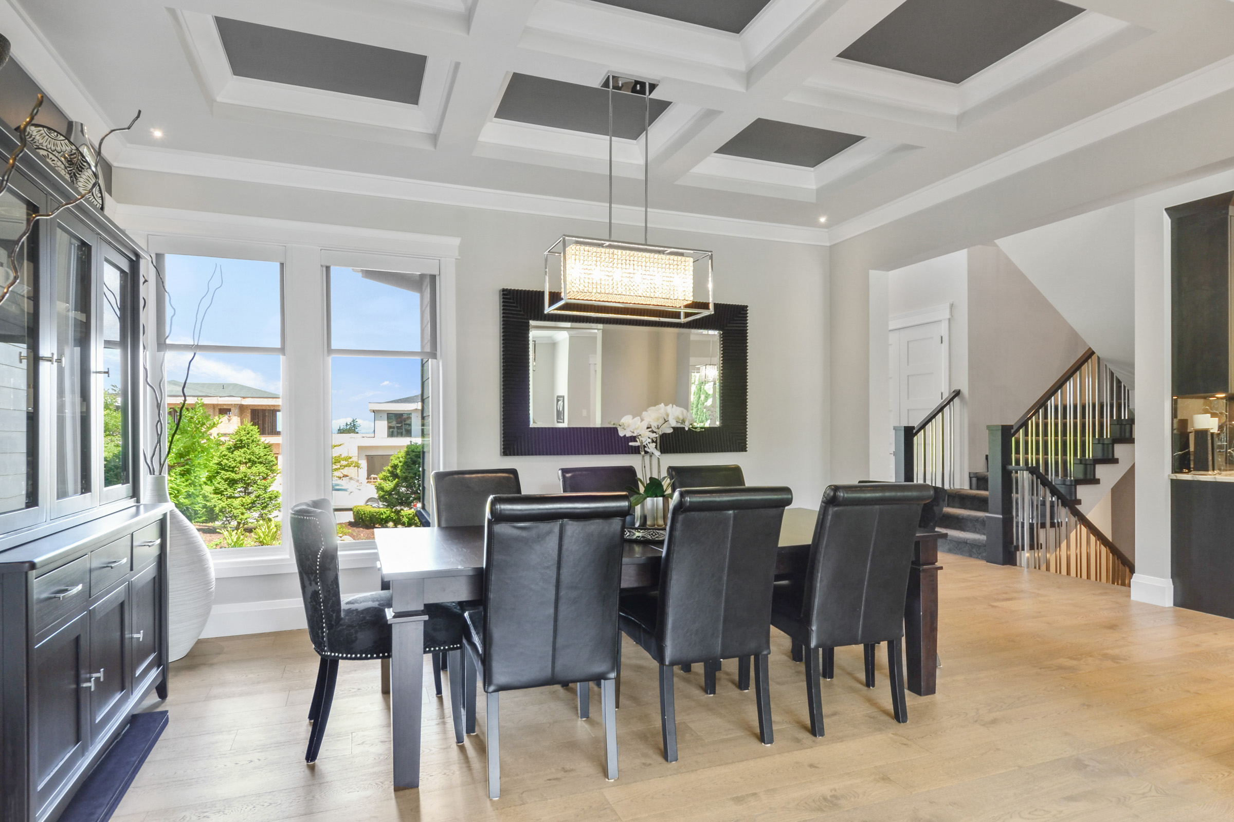 Dining room with coffered ceiling and black leather seating