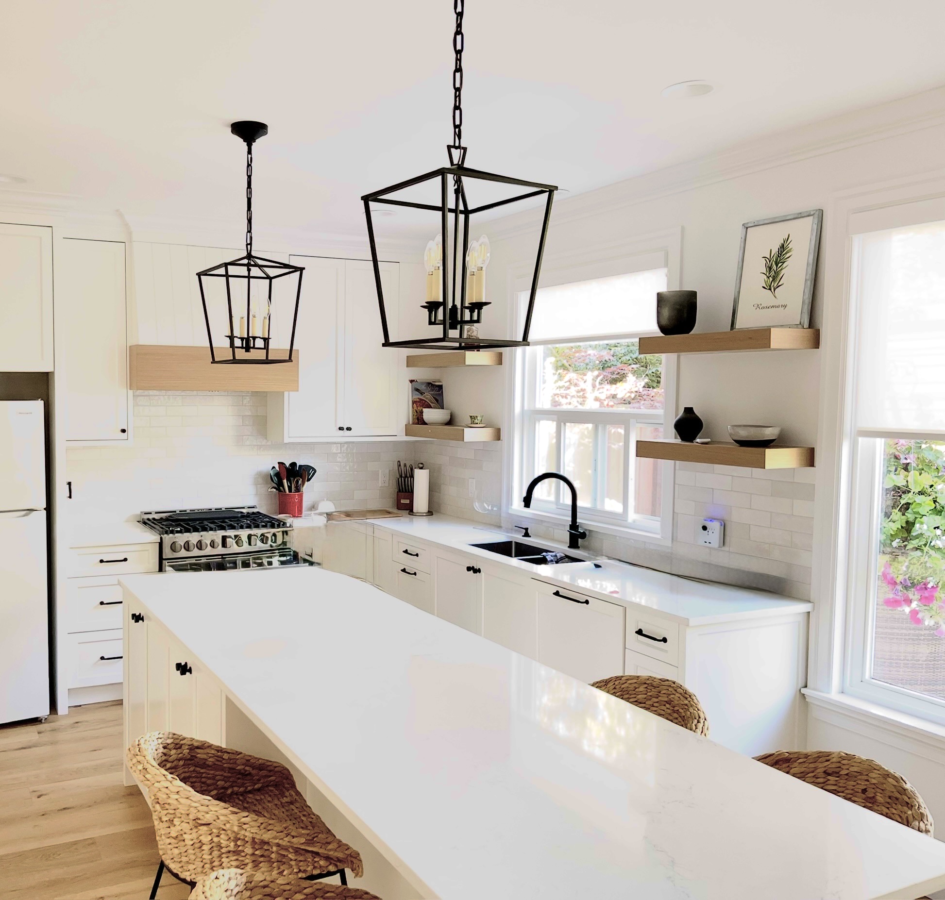 White farmhouse kitchen with black lantern pendants and floating oak shelves