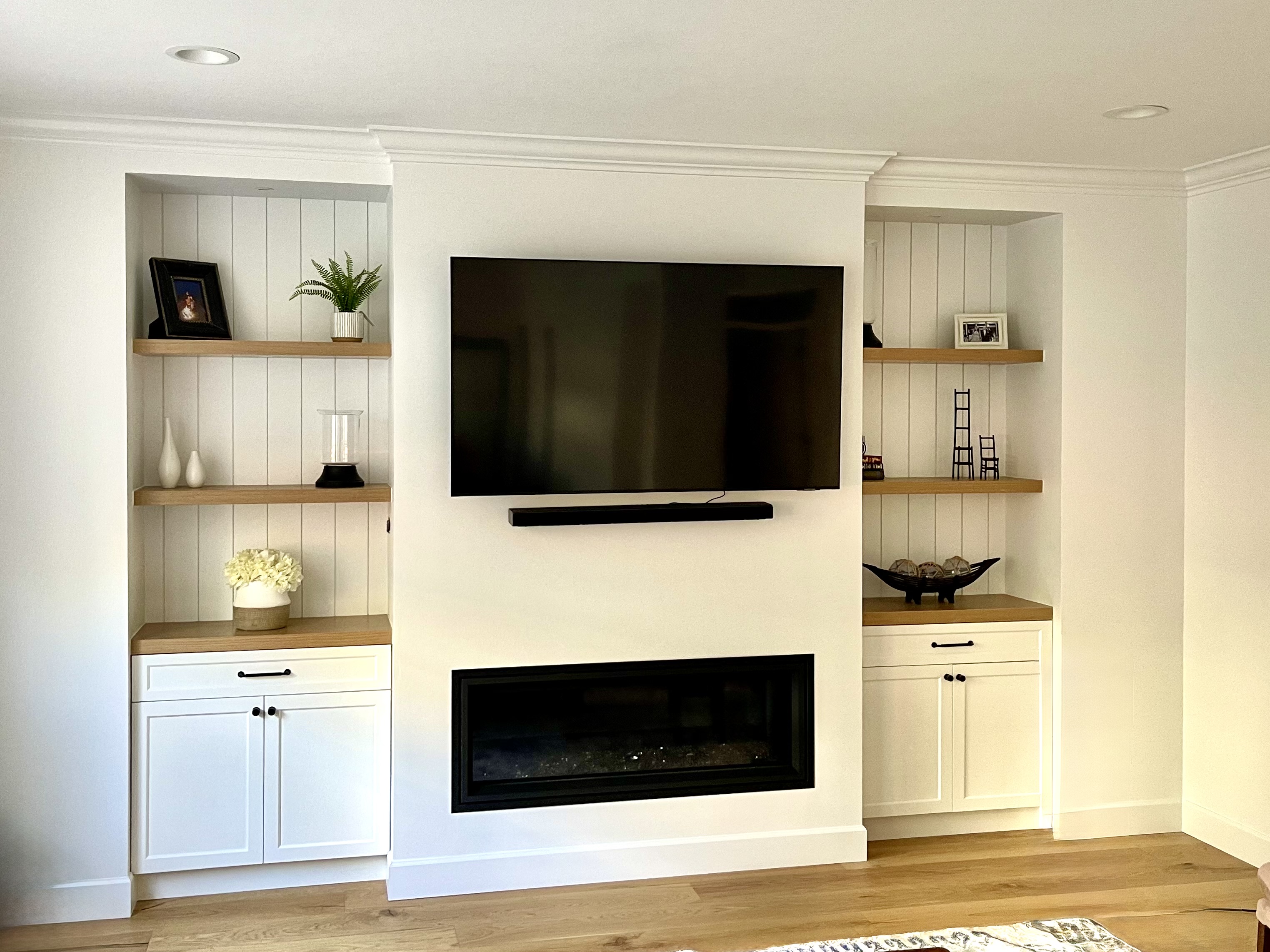 Custom built-in media wall with linear fireplace and floating oak shelves